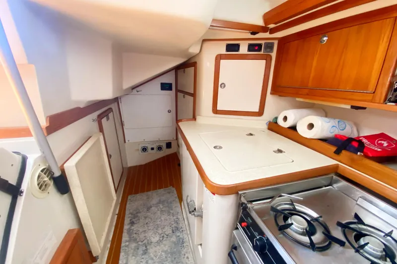 Slide: The Image of 2004 Catalina 42 MkII yacht interior kitchen with stove, cabinets, and storage space. - 25