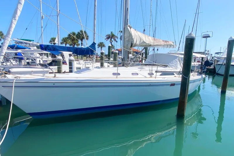 Slide: The Image of 2004 Catalina 42 MkII sailboat docked in a sunny marina with clear blue water. - 4