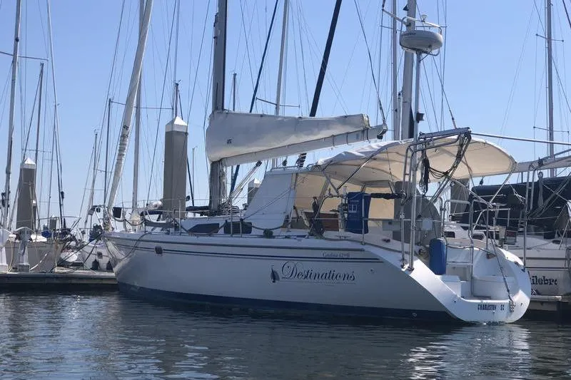 Slide: The Image of 2004 Catalina 42 sailboat docked at marina, featuring white hull and sail. - 3