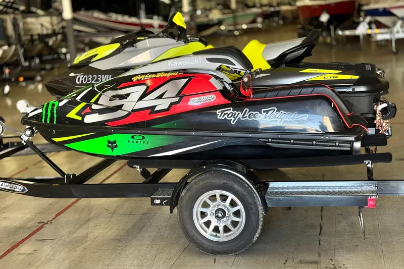 Slide: The Image of 2024 Kawasaki Jetski SX-R with custom graphics on a trailer in a showroom. - 5