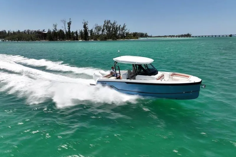 Slide: The Image of 2026 Wellcraft 28 T-Top boat cruising on turquoise water. - 4