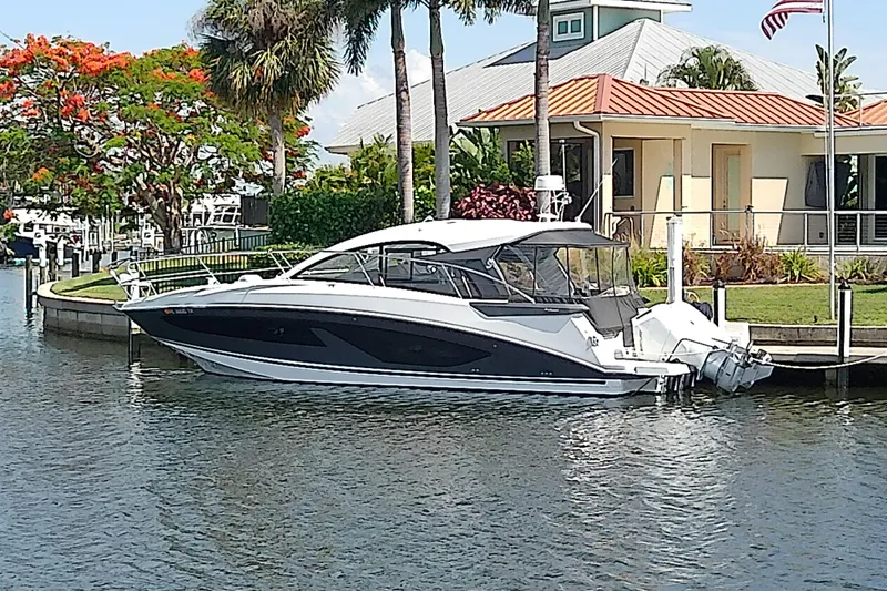 The Image of 2024 Beneteau Gran Turismo 36 yacht docked by a waterfront home. - 0