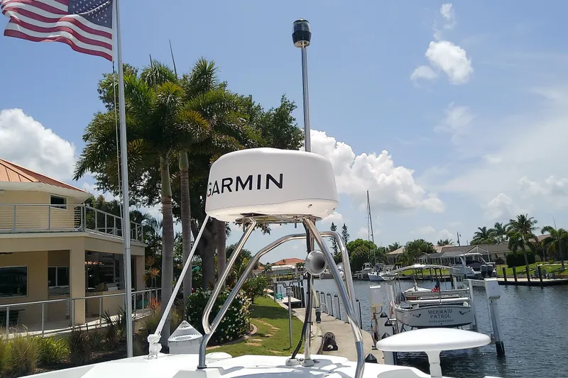 Slide: The Image of 2024 Beneteau Gran Turismo 36 with Garmin radar, docked near palm trees and American flag. - 12