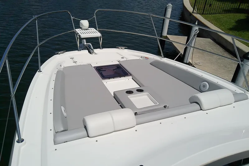 Slide: The Image of 2024 Beneteau Gran Turismo 36 yacht deck with sunbathing area and railing, docked by water. - 16