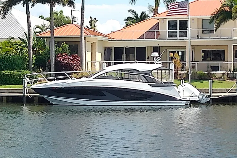 Slide: The Image of 2024 Beneteau Gran Turismo 36 yacht docked by waterfront home. - 2
