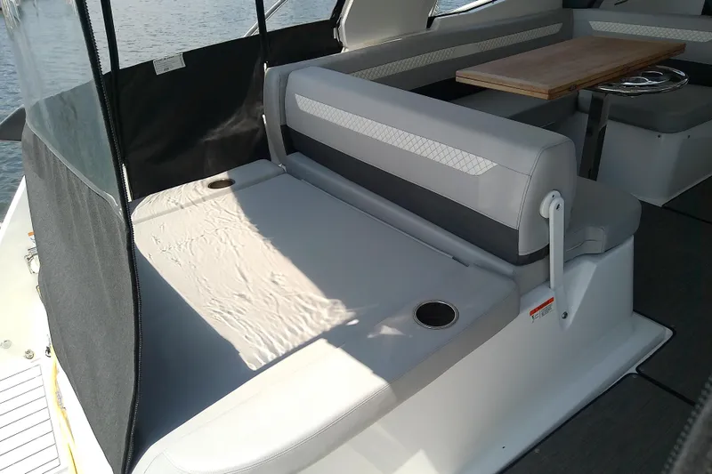 Slide: The Image of 2024 Beneteau Gran Turismo 36 interior seating area with table and cup holders. - 24