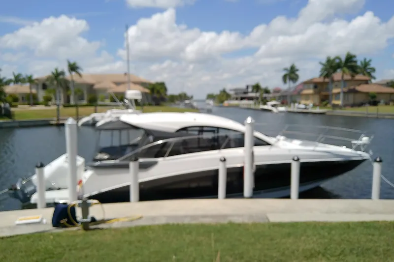 Slide: The Image of 2024 Beneteau Gran Turismo 36 yacht docked by a scenic waterfront with palm trees. - 3