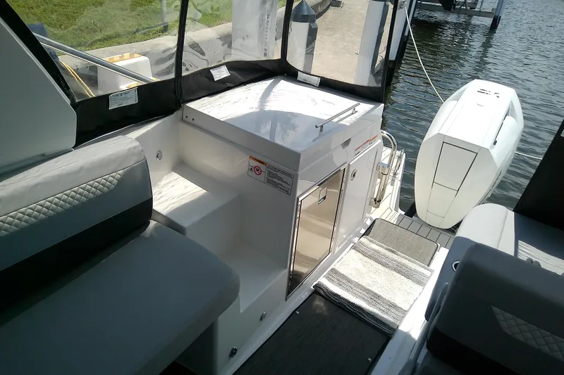 Slide: The Image of 2024 Beneteau Gran Turismo 36 interior with seating and outboard motor by the water. - 31