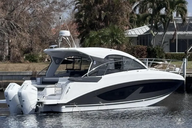 Slide: The Image of 2024 Beneteau Gran Turismo 36 yacht docked near lush greenery. - 5