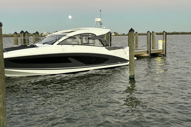 Slide: The Image of 2024 Beneteau Gran Turismo 36 yacht docked at a serene marina under a clear sky. - 6