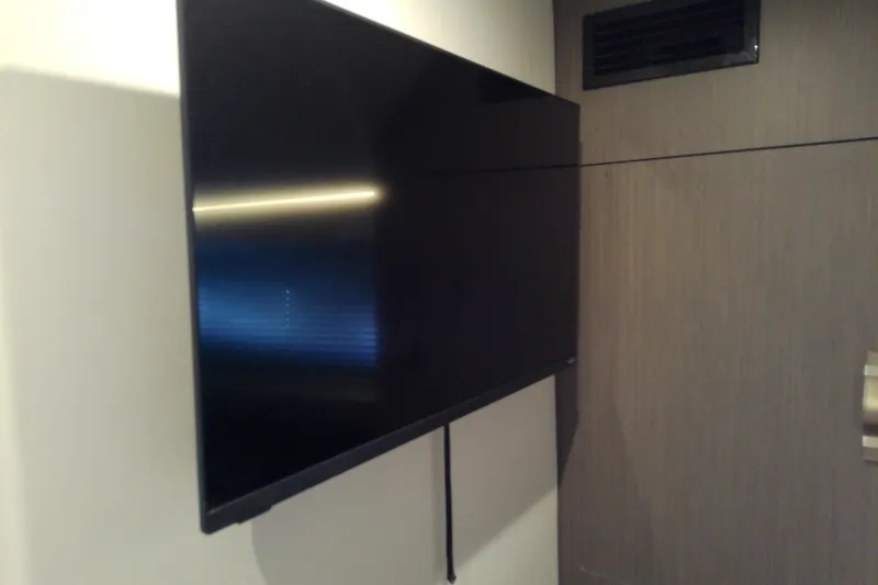 Slide: The Image of Flat-screen TV mounted on the wall inside a 2024 Beneteau Gran Turismo 36 yacht. - 83