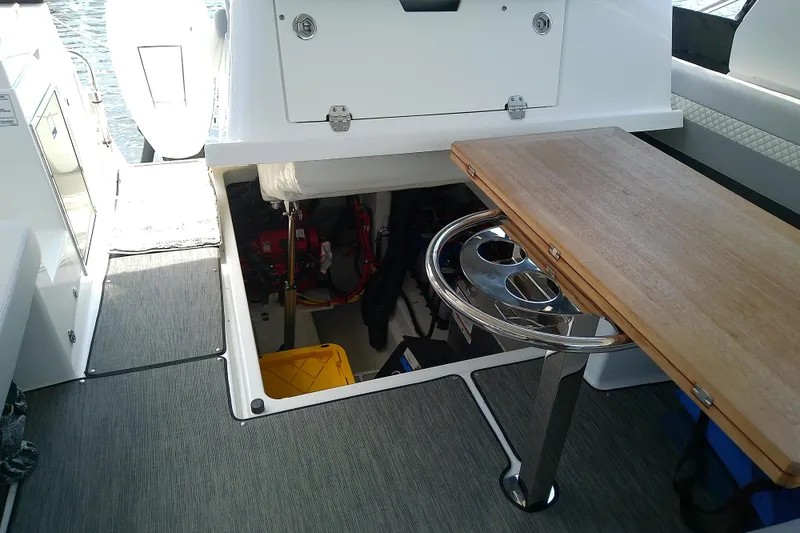Slide: The Image of 2024 Beneteau Gran Turismo 36 interior with open engine compartment and wooden table. - 84
