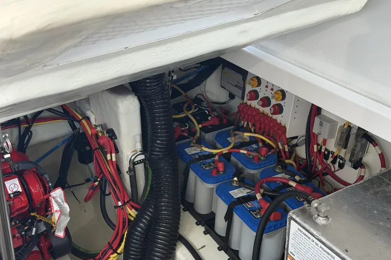 Slide: The Image of Engine compartment of 2024 Beneteau Gran Turismo 36, showcasing batteries and wiring. - 87