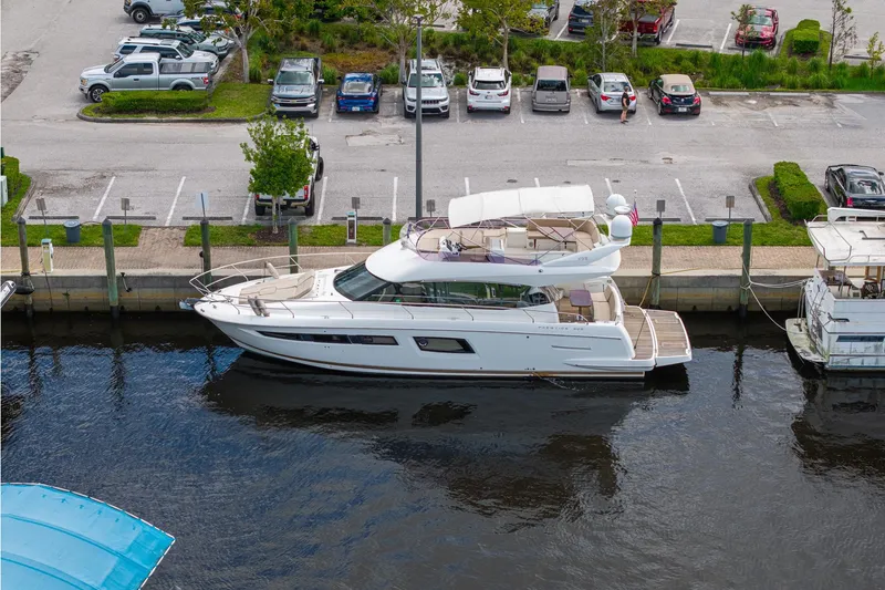 Slide: The Image of Luxury 2016 Prestige 500 yacht docked at marina, surrounded by parked cars. - 2