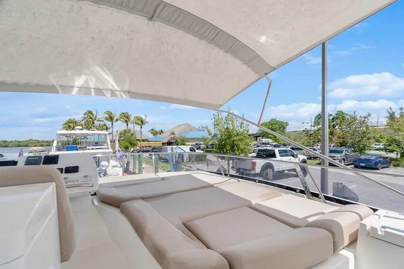 Slide: The Image of Luxurious 2016 Prestige 500 yacht with spacious deck, docked near palm trees and parked cars. - 33