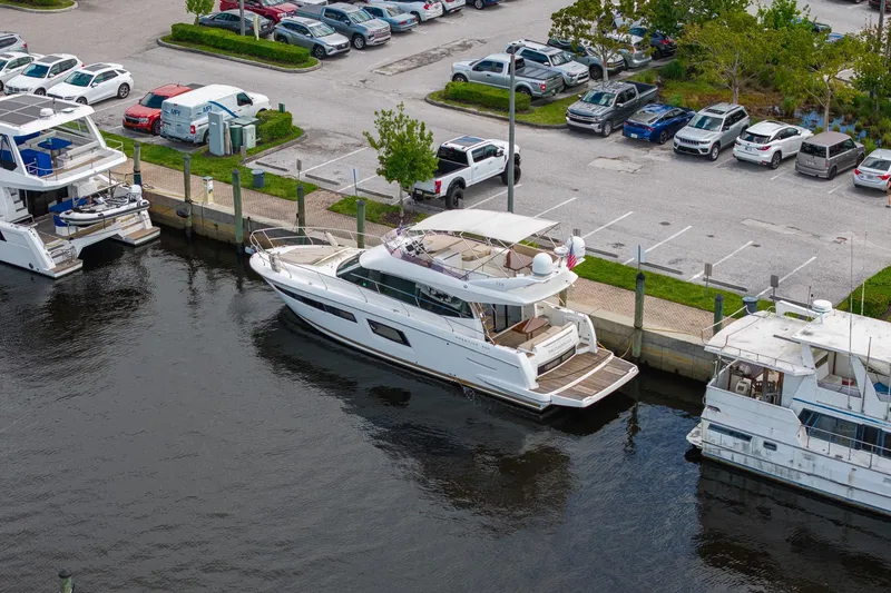 Slide: The Image of Aerial view of a 2016 Prestige 500 yacht docked at a marina with parked cars nearby. - 4