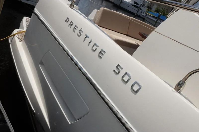 Slide: The Image of 2016 Prestige 500 yacht, sleek design with luxury seating, docked at marina. - 40