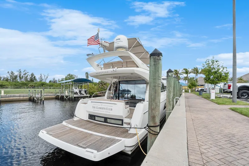 Slide: The Image of Luxury 2016 Prestige 500 yacht docked at marina under clear blue sky. - 7