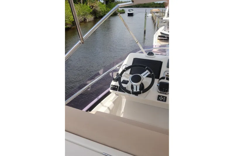 Slide: The Image of Helm of a 2016 Prestige 500 yacht, featuring modern controls and a scenic waterway view. - 73