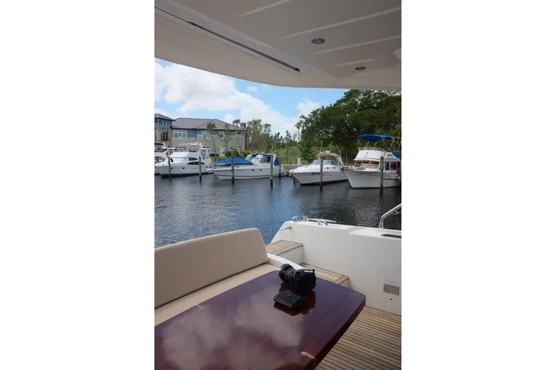 Slide: The Image of Prestige 500 yacht interior with marina view, featuring a camera on the table, 2016 model. - 74