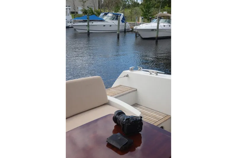 Slide: The Image of A 2016 Prestige 500 yacht with camera on table, docked near other boats. - 75