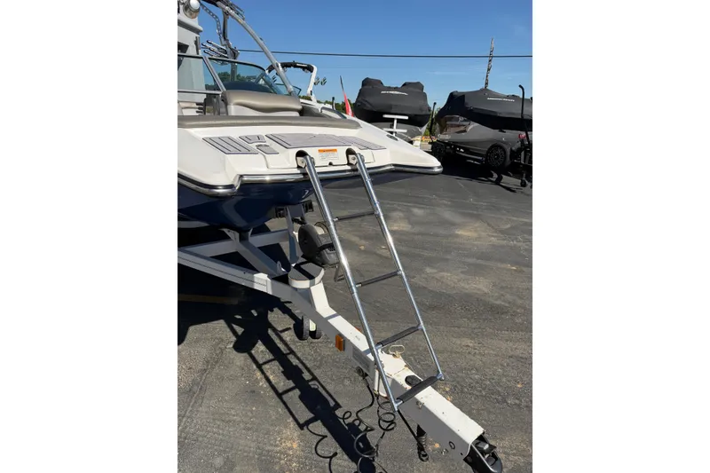 Slide: The Image of 2010 MasterCraft XStar boat with ladder on trailer in sunny outdoor setting. - 11