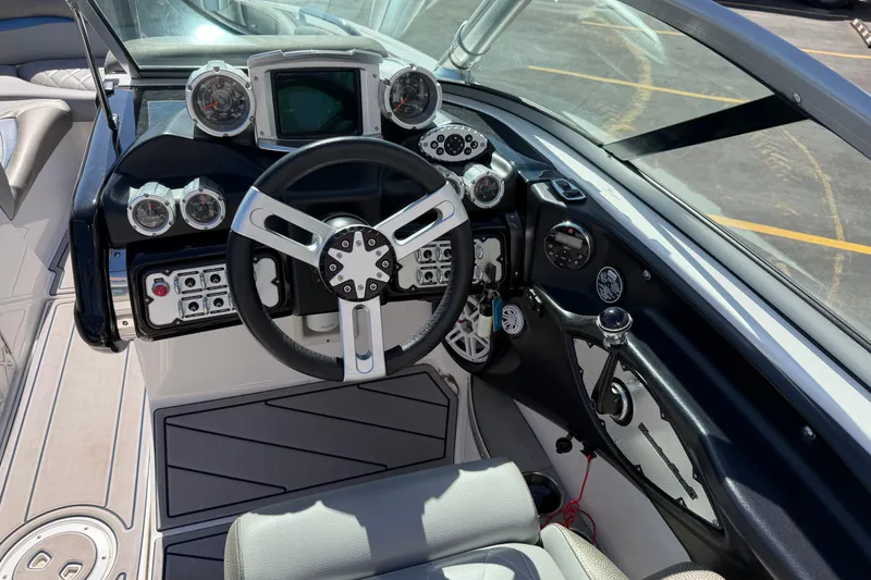 Slide: The Image of 2010 MasterCraft XStar boat dashboard with steering wheel and control gauges. - 18