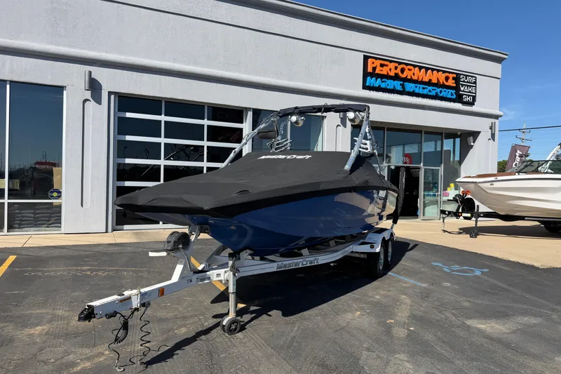 Slide: The Image of 2010 MasterCraft XStar boat on trailer outside Performance Marine Watersports store. - 27