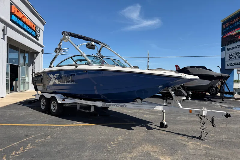 Slide: The Image of 2010 MasterCraft XStar boat on trailer outside dealership under clear blue sky. - 8