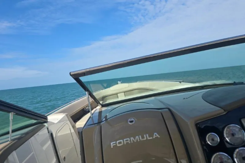 Slide: The Image of 2015 Formula 350 Crossover Bowrider I/O on open water under clear blue sky. - 15