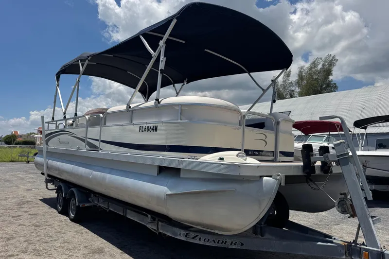 The Image of 2007 Bennington 2574 GL pontoon boat on trailer under blue sky. - 1