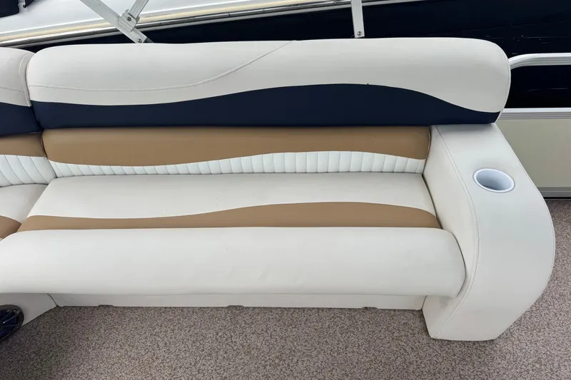 Slide: The Image of 2007 Bennington 2574 GL boat seat with beige, white, and navy upholstery, featuring a cup holder. - 24