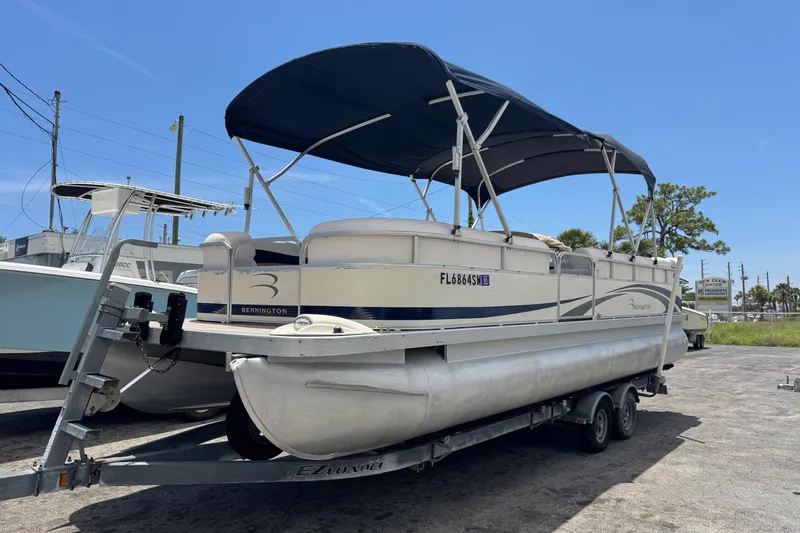Slide: The Image of 2007 Bennington 2574 GL pontoon boat on trailer under blue sky. - 3