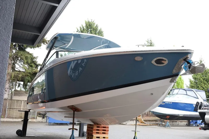 Slide: The Image of 2021 Cobalt R30 boat on stands, blue hull, outdoor setting. - 16