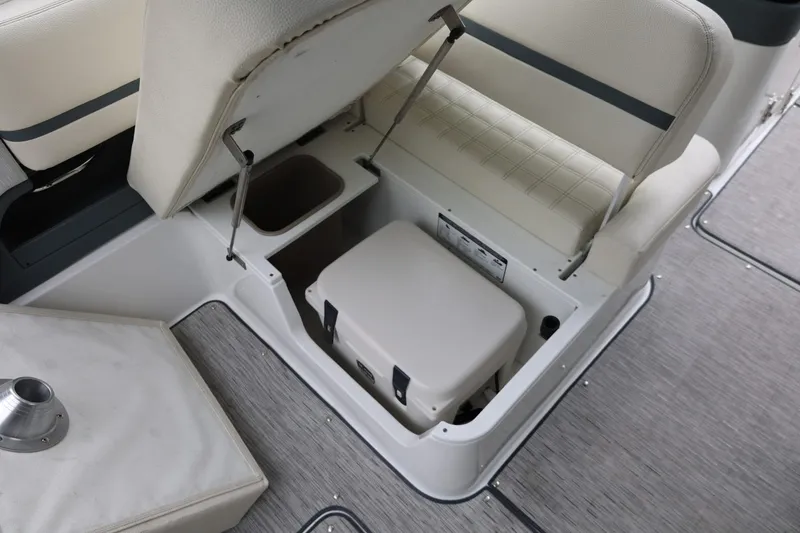 Slide: The Image of 2021 Cobalt R30 boat interior storage compartment with cushioned seating and cooler. - 34