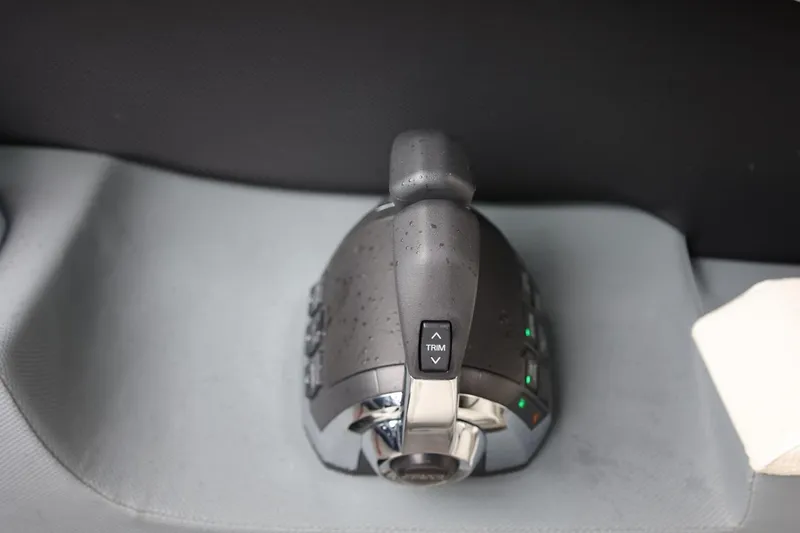 Slide: The Image of Throttle control lever on a 2021 Cobalt R30 boat, featuring trim adjustment buttons. - 49