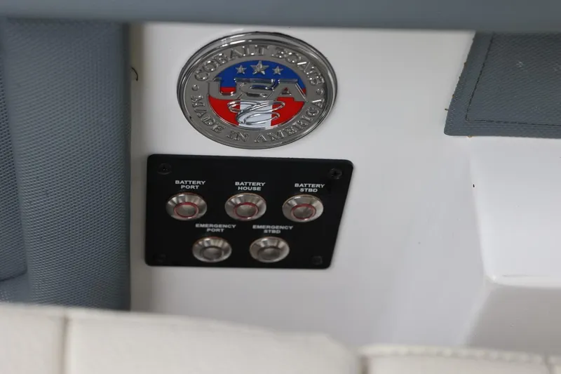 Slide: The Image of Control panel and emblem on a 2021 Cobalt R30 boat, showcasing battery switches. - 50
