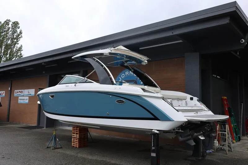 Slide: The Image of 2021 Cobalt R30 boat in blue and white, elevated for maintenance outside a building. - 7