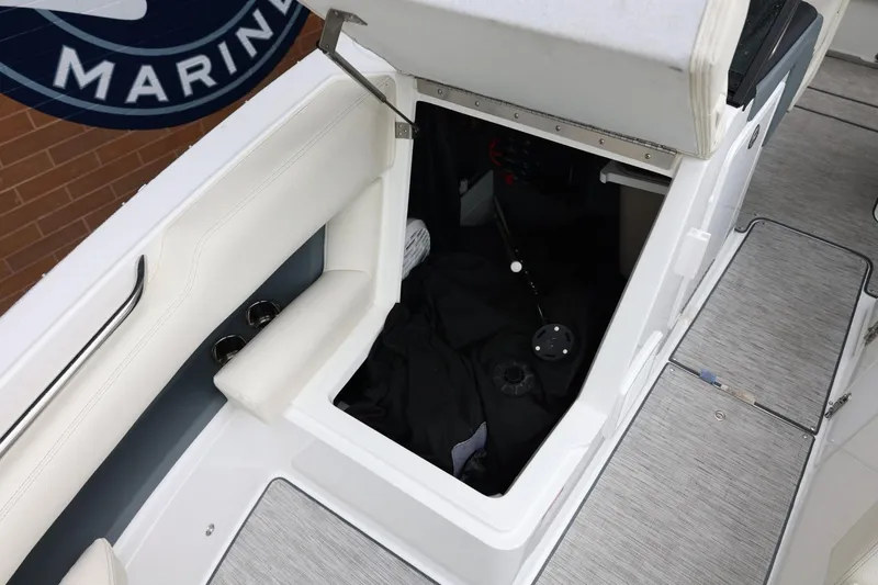 Slide: The Image of 2021 Cobalt R30 boat storage compartment with open hatch and white seating. - 71