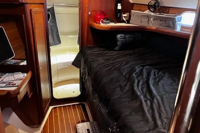 Slide: The Image of Cozy cabin interior of a 1996 Hunter 430 sailboat with wooden accents and a black bedspread. - 5
