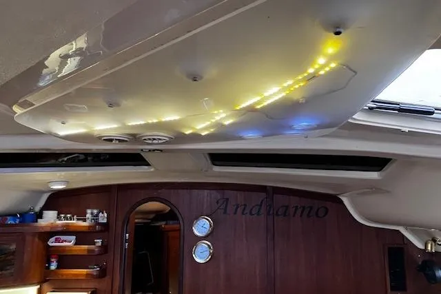 Slide: The Image of Interior of a 1996 Hunter 430 sailboat with illuminated ceiling and wooden cabinetry. - 6