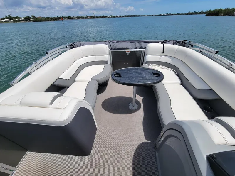 Slide: The Image of 2021 Godfrey Marine Monaco pontoon boat with seating area on the water. - 5