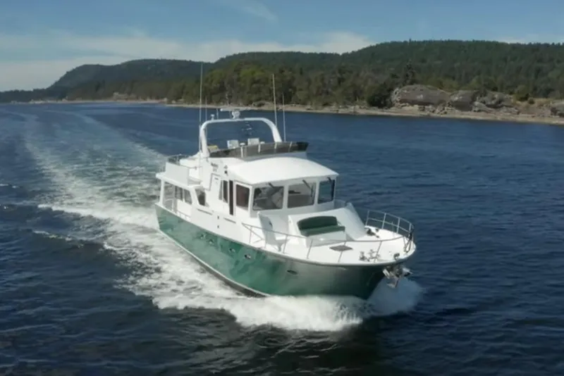 The Image of 2003 Jefferson Pilothouse 53 yacht cruising on scenic waterway with forested hills. - 0