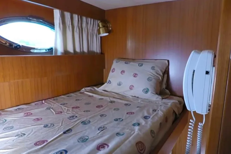 Slide: The Image of Cozy cabin interior of 2003 Jefferson Pilothouse 53 yacht with bed and porthole window. - 10