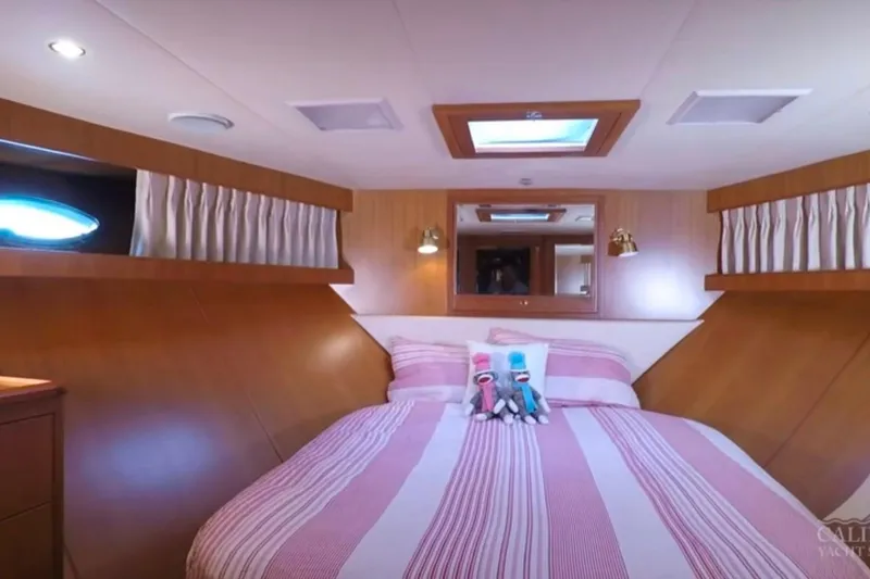 Slide: The Image of Luxurious bedroom interior of 2003 Jefferson Pilothouse 53 yacht with striped bedding and plush toys. - 11
