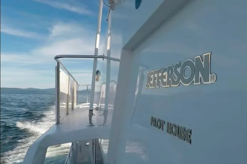 Slide: The Image of 2003 Jefferson Pilothouse 53 yacht cruising on open water under a clear sky. - 13