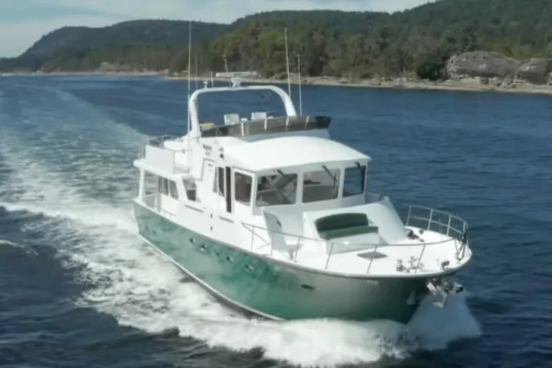 Slide: The Image of 2003 Jefferson Pilothouse 53 yacht cruising on scenic waterway with forested shoreline. - 22