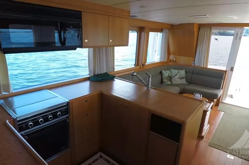 Slide: The Image of Interior of 2003 Jefferson Pilothouse 53 yacht with kitchen and seating area. - 7