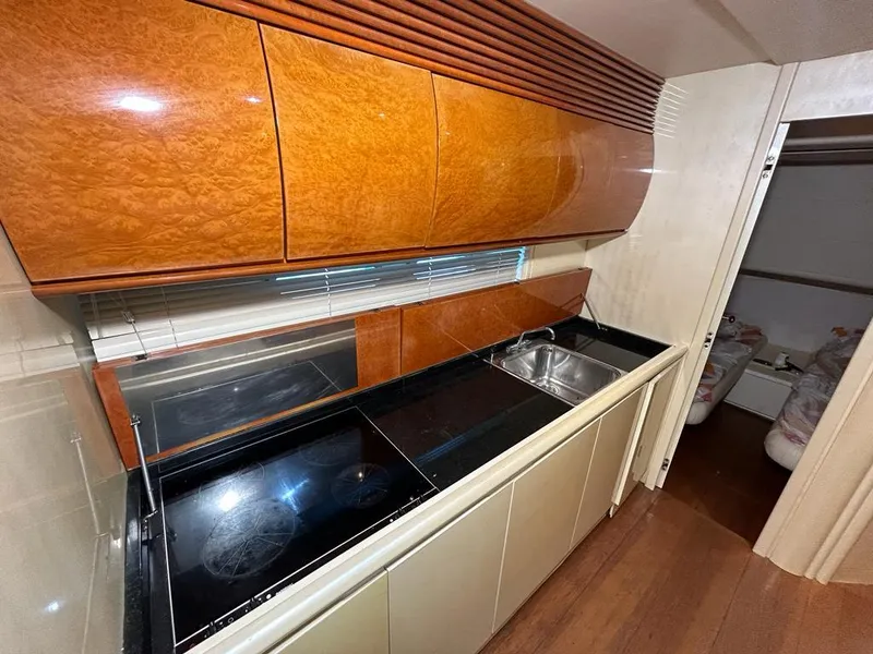 Slide: The Image of 1999 Pershing 54 yacht kitchen with modern appliances and wooden cabinetry. - 22