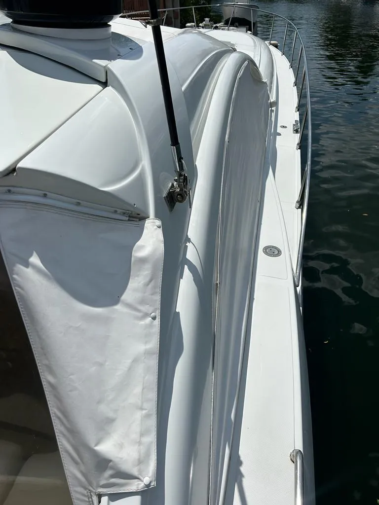 Slide: The Image of 1999 Pershing 54 yacht side view, docked on calm water. - 38